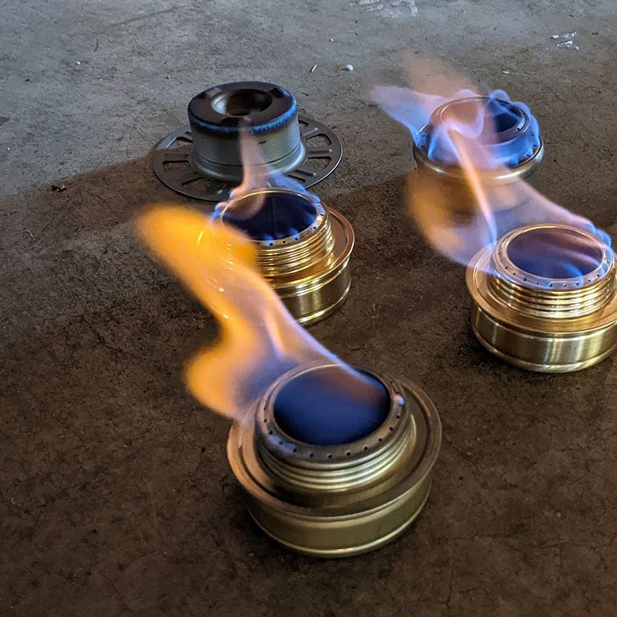 Backpacker using an alcohol stove in outdoor setting