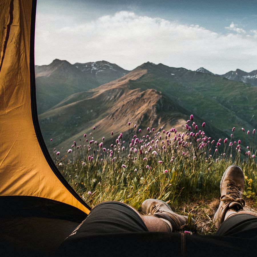 Adventurous camper cooking on a compact camping stove in the wilderness